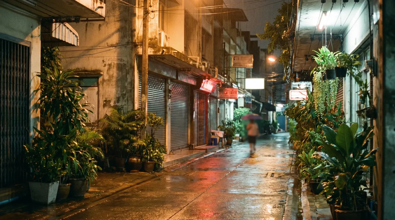 A quiet Bangkok soi glowing with warm streetlamps late at night